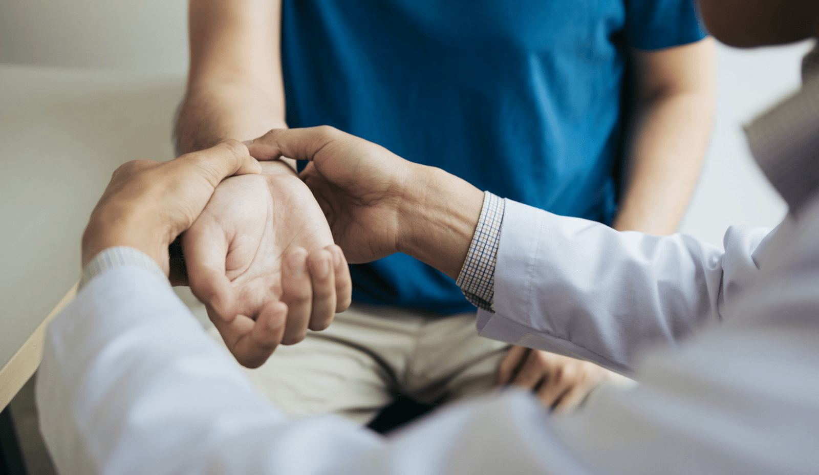 Arzt untersucht das Handgelenk eines Patienten – Fokus auf mögliche Nervenschädigung oder Karpaltunnelsyndrom.